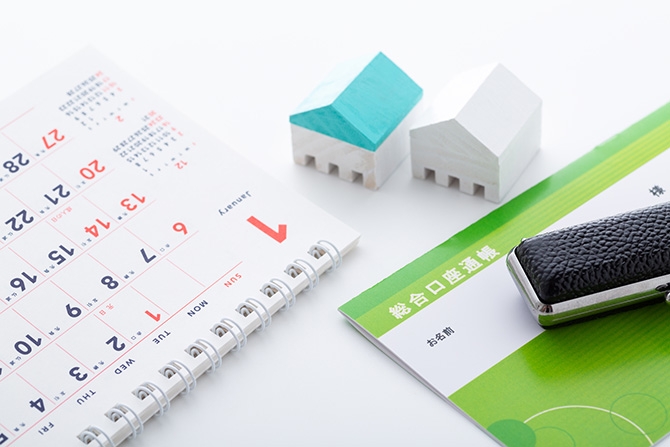 預金通帳と家の模型イメージ