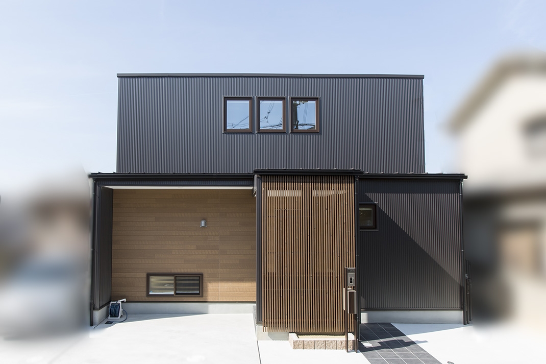 黒い外壁と木目の玄関アプローチの家